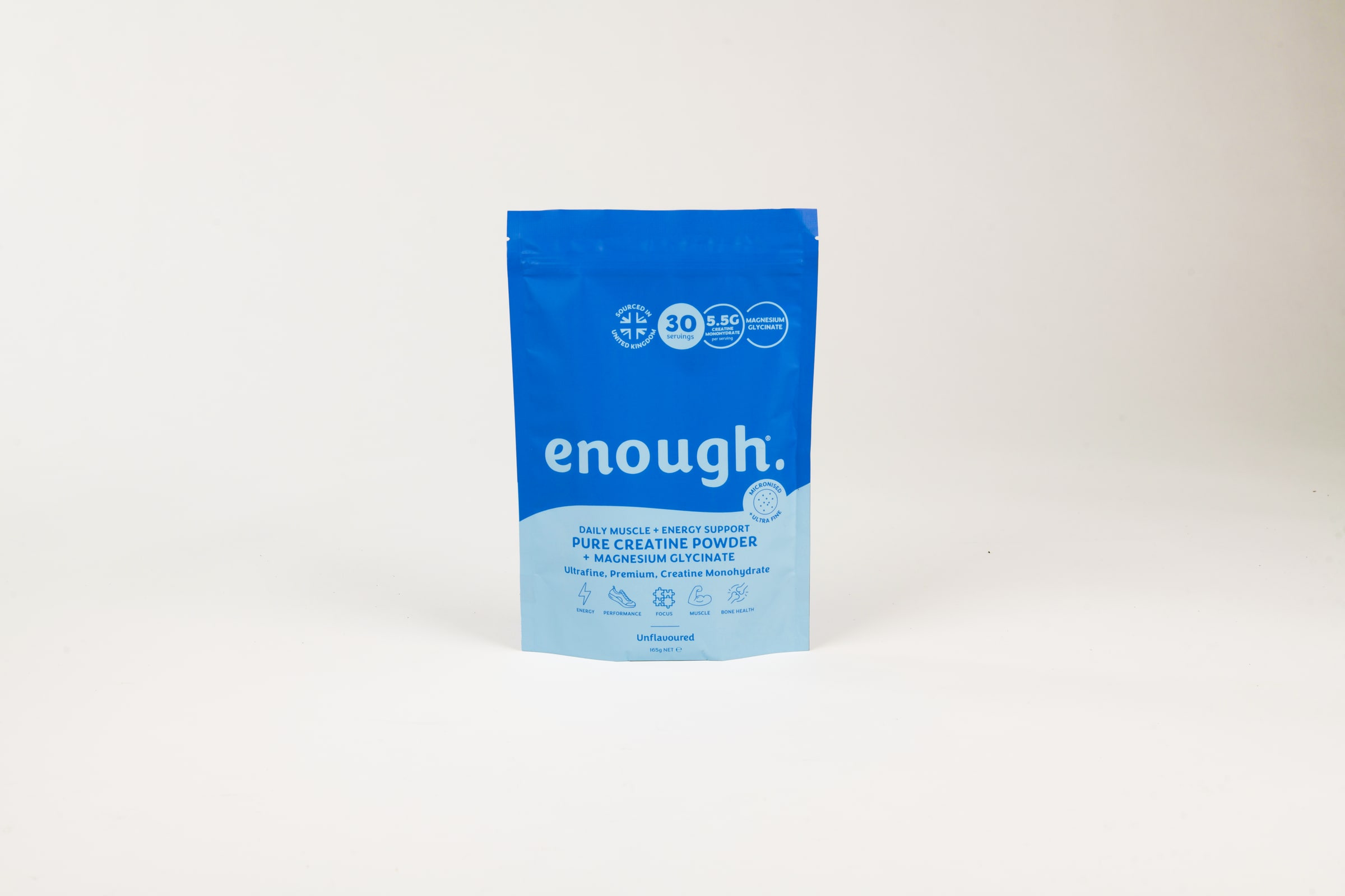 A single blue Enough Wellness creatine powder pouch standing upright in the middle of a seamless white studio backdrop