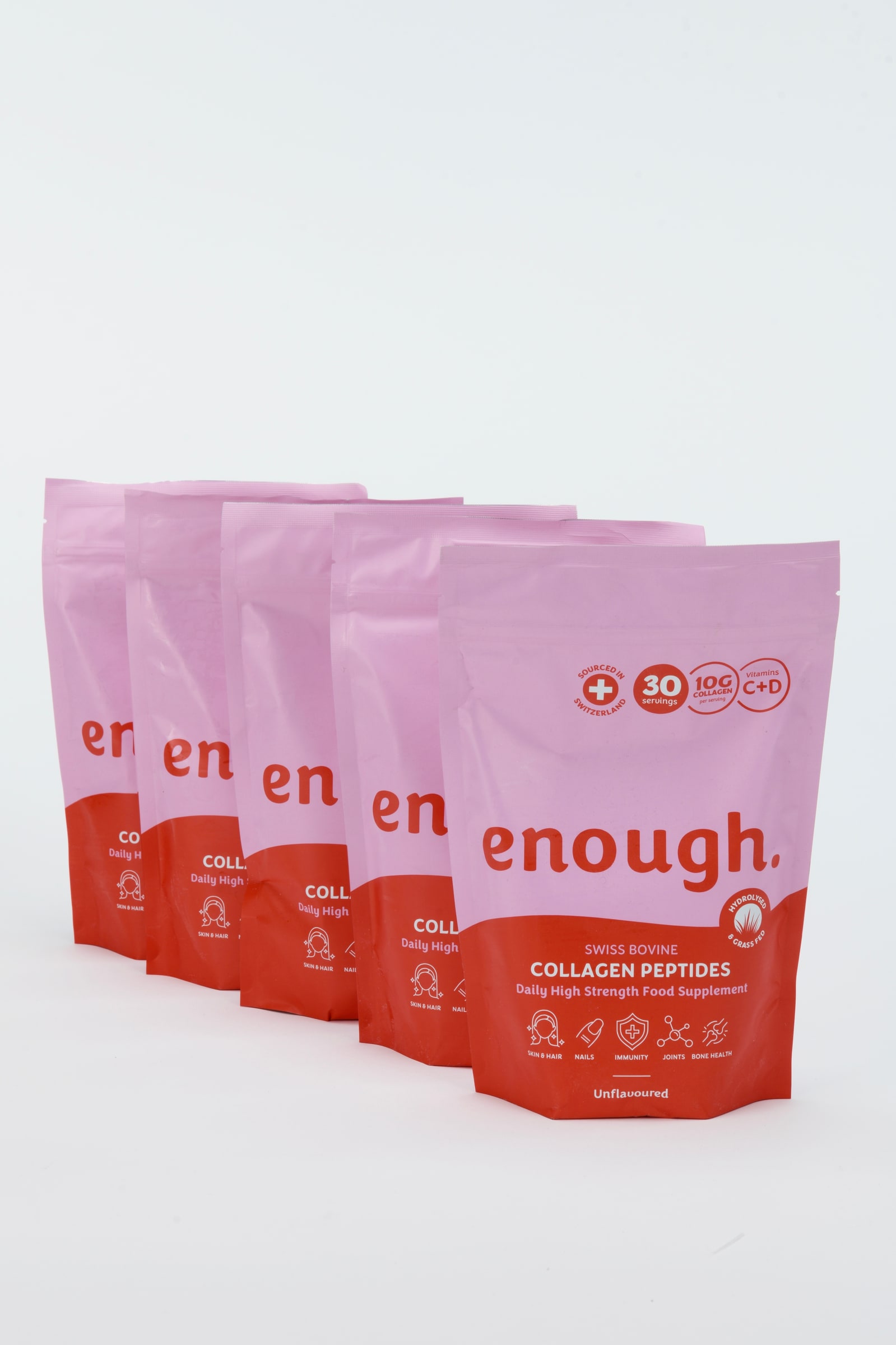 Five pink Enough Wellness collagen peptides pouches lined up in a staggered row on a clean white background